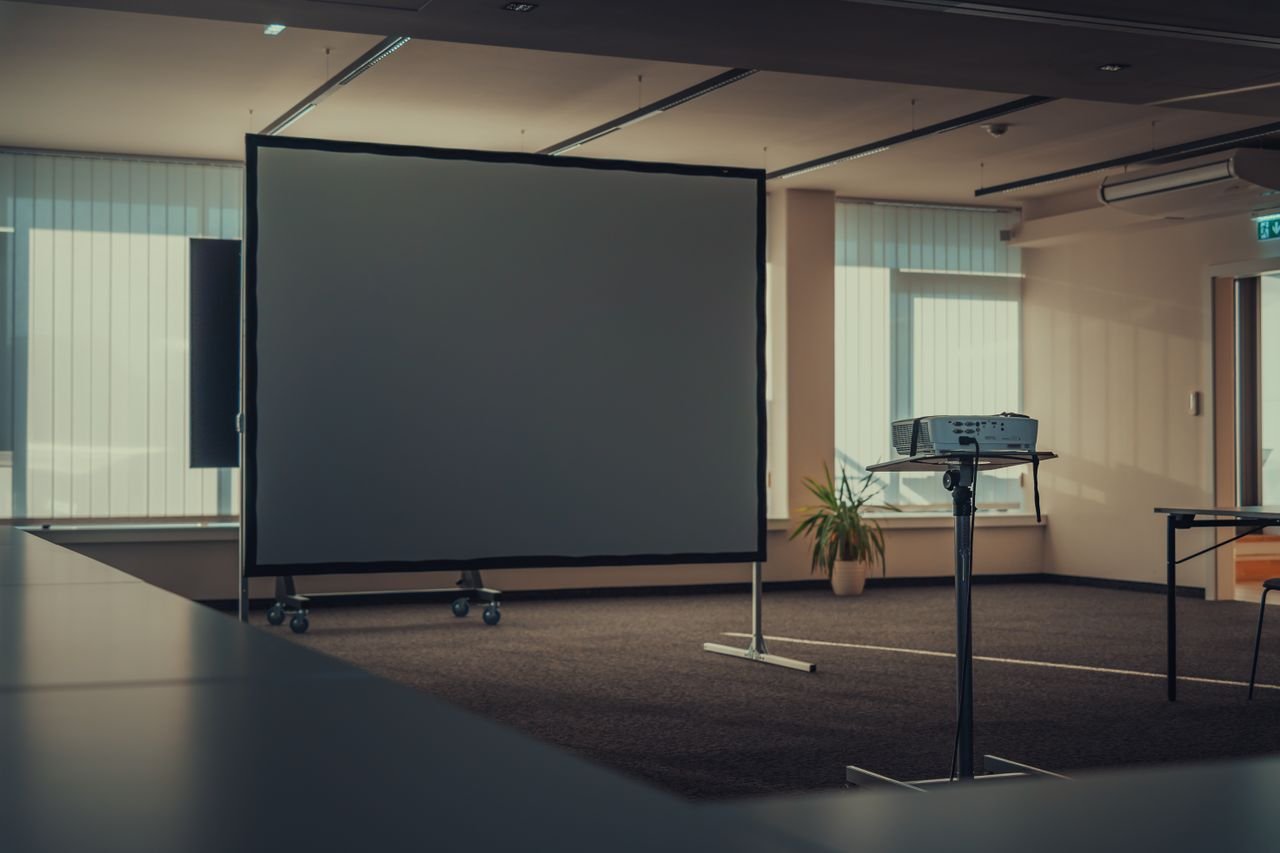 Projector and presentation screen set up in an office meeting room